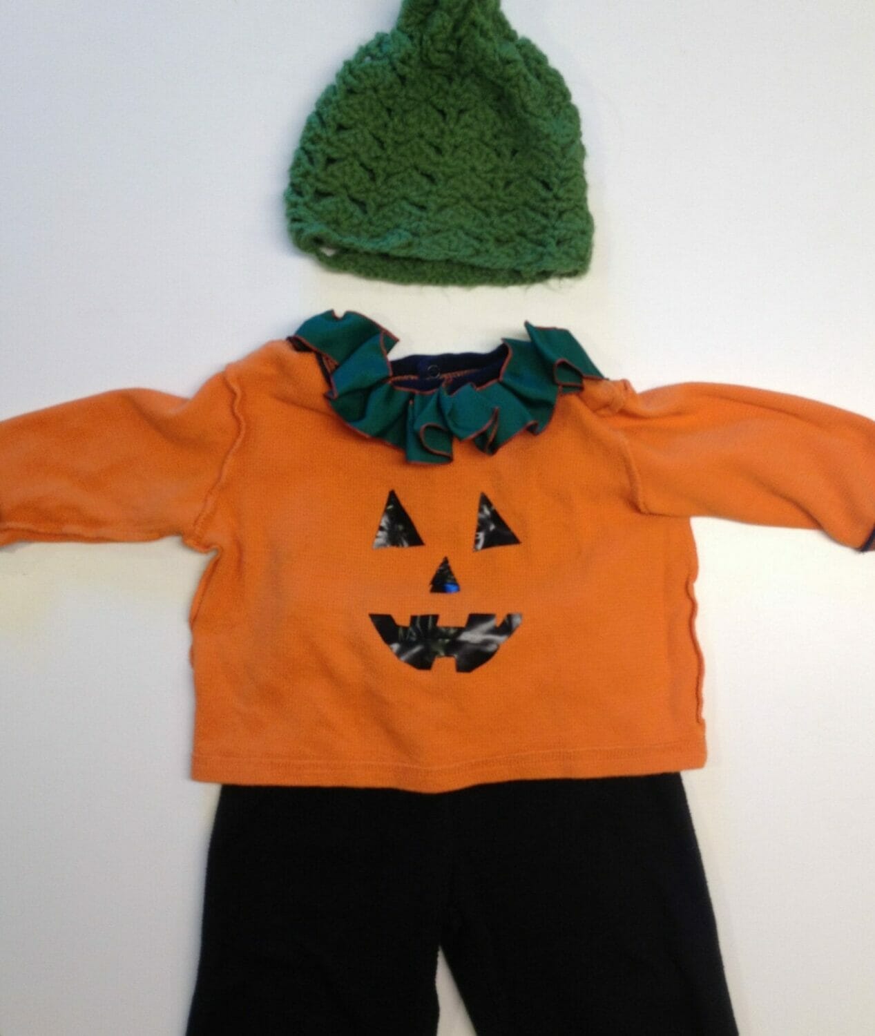 All you need to make a jack-o-lantern Halloween costume is an orange long-sleeve Tshirt, some black pants, black felt or tape, and scissors; the green ribbon collar and hand-crocheted hat are optional.