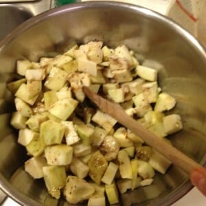 tossing eggplant with dressing