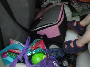 I usually pack our cooler bag at Essie's feet, next to our eating-out bag, so it's easy for me to grab when we stop, but hard for the girls to reach when they're strapped in.