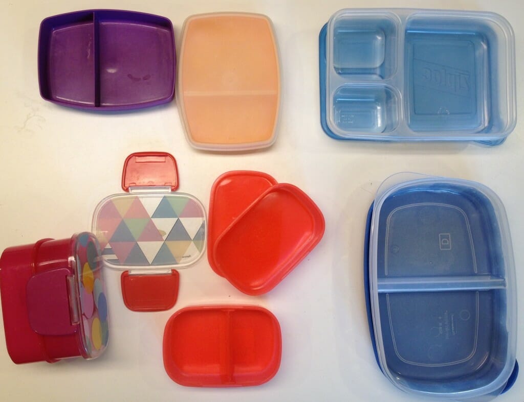 Clockwise from upper left: our two Tupperware snack boxes, our Ziploc compartmentalized container, our Rubbermaid divided Serving Saver, and our two Target "tiffin boxes."