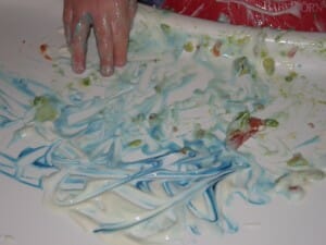 A fun way to let babies make art at mealtime is to put a dollop of plain yogurt on their highchair tray, add a drop of food coloring, and let them "paint."