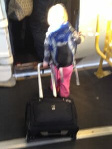 Essie, age three, boarding a plane last winter with her own luggage.